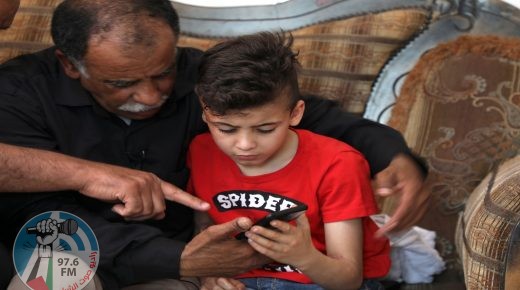 Hussein Dawabsha (L) sits with his grandson Ahmed, the survivor of the arson attack that killed his parents and 18-month-old brother, as they look at images on a phone at their home in the Israeli occupied West Bank village of Duma on May 18, 2020, after an Israeli court convicted a Jewish settler on three counts of murder over a 2015 arson attack. - Amiram Ben-Uliel, 25, from the West Bank settlement of Shilo, was also found guilty of two counts each of attempted murder and arson, along with conspiracy to commit a hate crime, a court statement said. (Photo by JAAFAR ASHTIYEH / AFP) (Photo by JAAFAR ASHTIYEH/AFP via Getty Images)