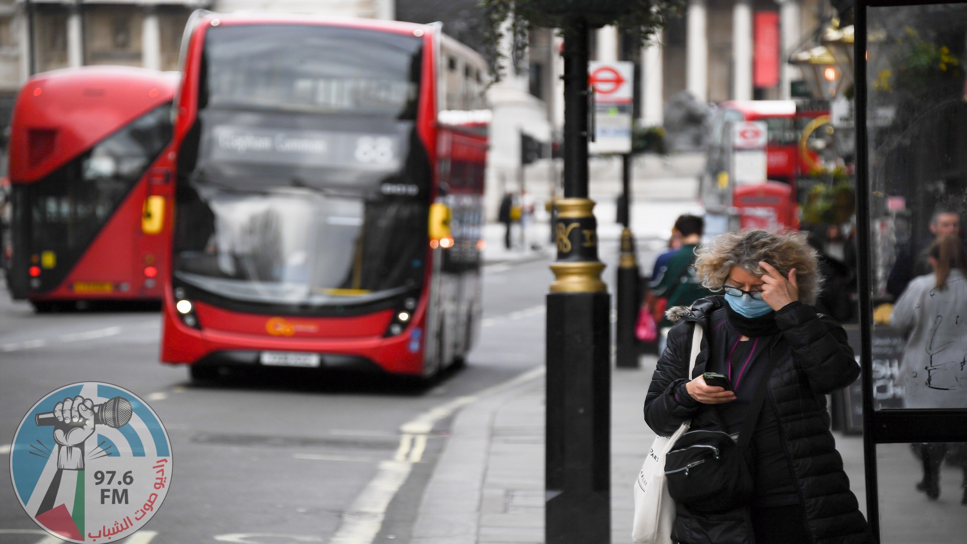 A woman wears a mask as a bus passes on March 17, 2020 in London, England. Boris Johnson held the first of his public daily briefings on the Coronavirus outbreak yesterday and told the public to avoid theatres and pubs and to work from home where possible. The number of people infected with COVID-19 in the UK has passed 1500 with 55 deaths. (Photo by Alberto Pezzali/NurPhoto via Getty Images)