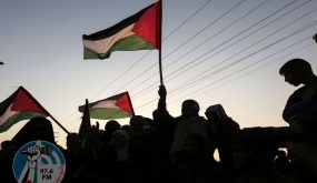 TOPSHOT - Palestinian protesters wave their national flags at sunset during a demonstration near the Erez crossing with Israel on September 4, 2018, in the northern Gaza Strip protesting against the United States decision to stop funding and backing the United Nations agency for Palestinian refugees(UNRWA). (Photo by MAHMUD HAMS / AFP)
