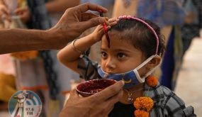 A volunteer applies a tilak on the forehead of a girl after offering prayers to the idol of Hindu goddess Kali at the historical Bhadrakali temple in Amritsar on June 7, 2021. / AFP / Narinder NANU