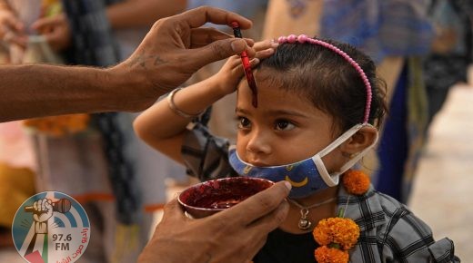 A volunteer applies a tilak on the forehead of a girl after offering prayers to the idol of Hindu goddess Kali at the historical Bhadrakali temple in Amritsar on June 7, 2021. / AFP / Narinder NANU