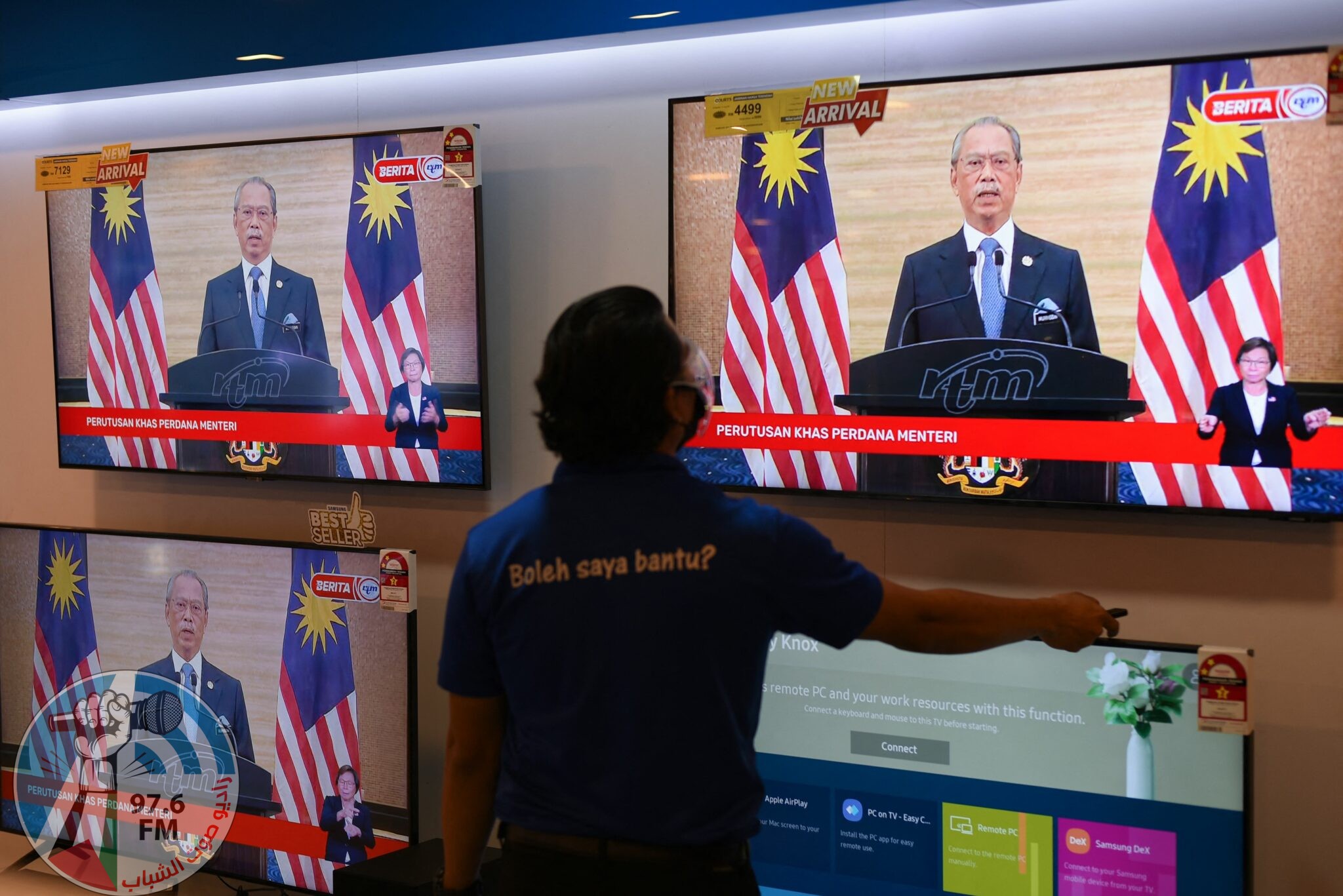A man watches a television on display at a shopping mall store as Malaysian Prime Minister Muhyiddin Yassin announces his resignation as he addresses the nation during a live telecast in Kuala Lumpur on August 16, 2021. (Photo by Arif KARTONO / AFP)