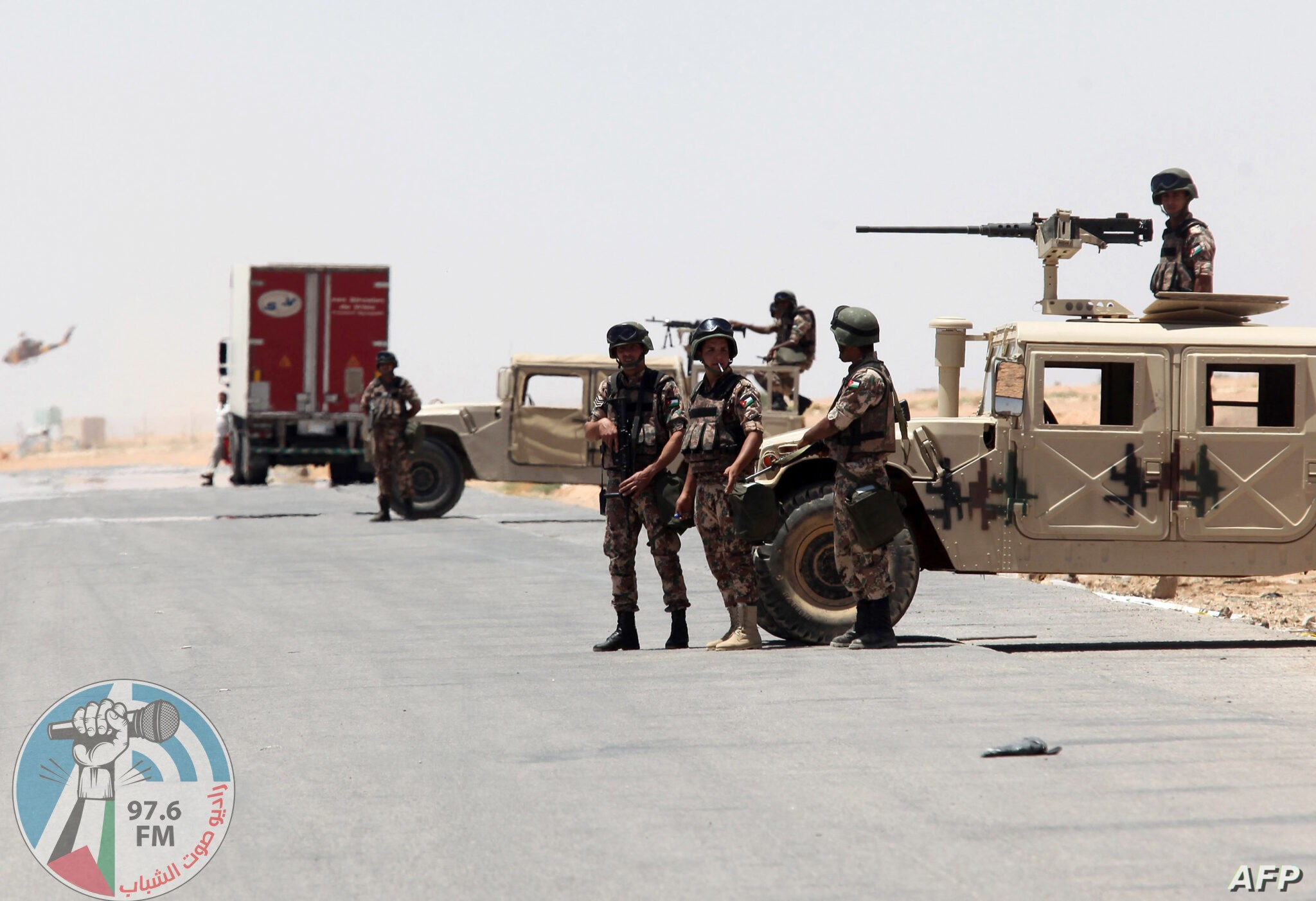 Jordanian soldiers stand guard near their military vehicles at the Al-Karameh border point with Iraq on June 25, 2014 as Jordan reinforced its border with Iraq after Sunni Arab militants overran a crossing with Syria. Sunni insurgents led by the jihadist Islamic State of Iraq and the Levant (ISIL) overran swathes of land north and west of Baghdad this month sparking fears in Amman that they will take the fight to Jordan, which is already struggling with its own home-grown Islamists. AFP PHOTO/STR