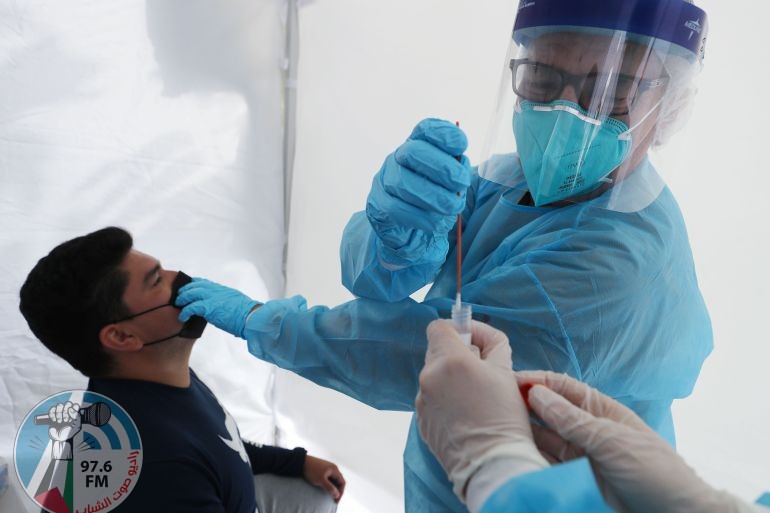 LOS ANGELES, CALIFORNIA - JULY 15: Dr. Glenn Lopez administers a COVID-19 test to Daniel Contreras at a St. Johns Well Child & Family Center mobile clinic set up outside Walker Temple AME Church in South Los Angeles amid the coronavirus pandemic on July 15, 2020 in Los Angeles, California. A clinic official said most of the residents they are currently testing in their South L.A. clinics are Latinos. According to the California Department of Health, Latinos are currently 2.9 times more likely than white people to test positive for the coronavirus. California reported over 11,000 new coronavirus infections today, the most in the state in a single day since the pandemic began. Mario Tama/Getty Images/AFP
== FOR NEWSPAPERS, INTERNET, TELCOS & TELEVISION USE ONLY ==