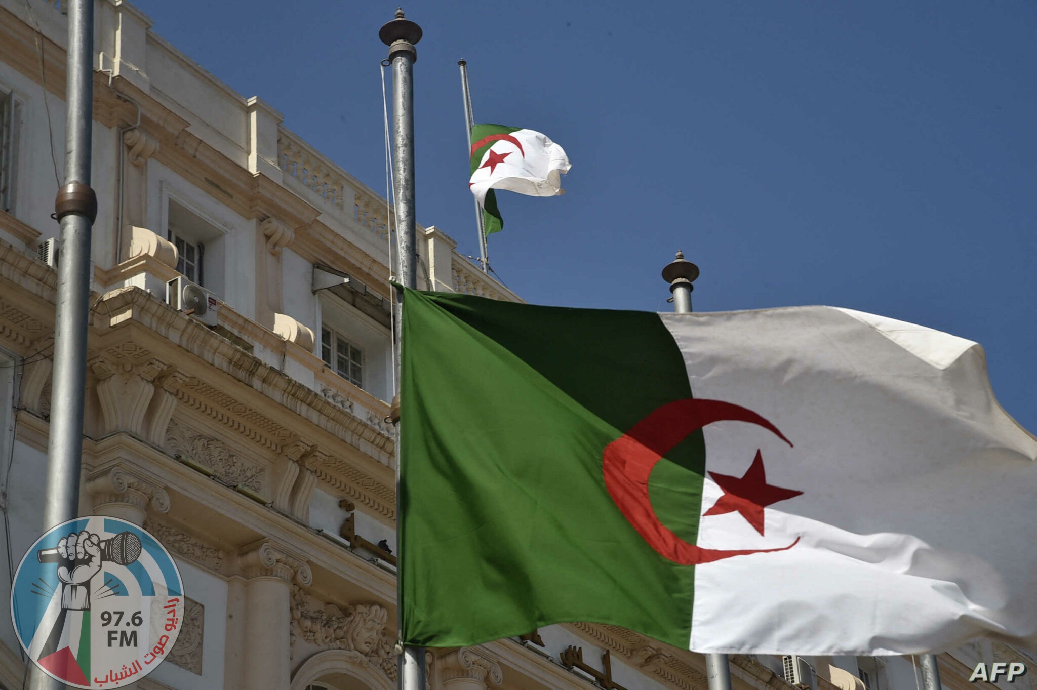 The Algerian national flag flies at half mast in the capital Algiers on September 18, 2021, following the death of former president Abdelaziz Bouteflika. - Bouteflika, who ruled Algeria for two decades before resigning in 2019 as huge protests engulfed the country, has died aged 84, public television announced. The former strongman had left office in April 2019 under pressure from the military, following weeks of demonstrations over his bid to run for a fifth term in office. (Photo by RYAD KRAMDI / AFP)
