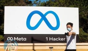 TOPSHOT - A person takes a selfie in front of a newly unveiled logo for "Meta", the new name for Facebook's parent company, outside Facebook headquarters in Menlo Park on October 28, 2021. Facebook changed its parent company name to "Meta" on October 28 as the tech giant tries to move past being a scandal-plagued social network to its virtual reality vision for the future. (Photo by NOAH BERGER / AFP)