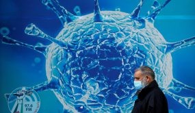 FILE PHOTO: A man wearing a protective face mask walks past an illustration of a virus outside a regional science centre amid the coronavirus disease (COVID-19) outbreak, in Oldham, Britain August 3, 2020. REUTERS/Phil Noble/File Photo