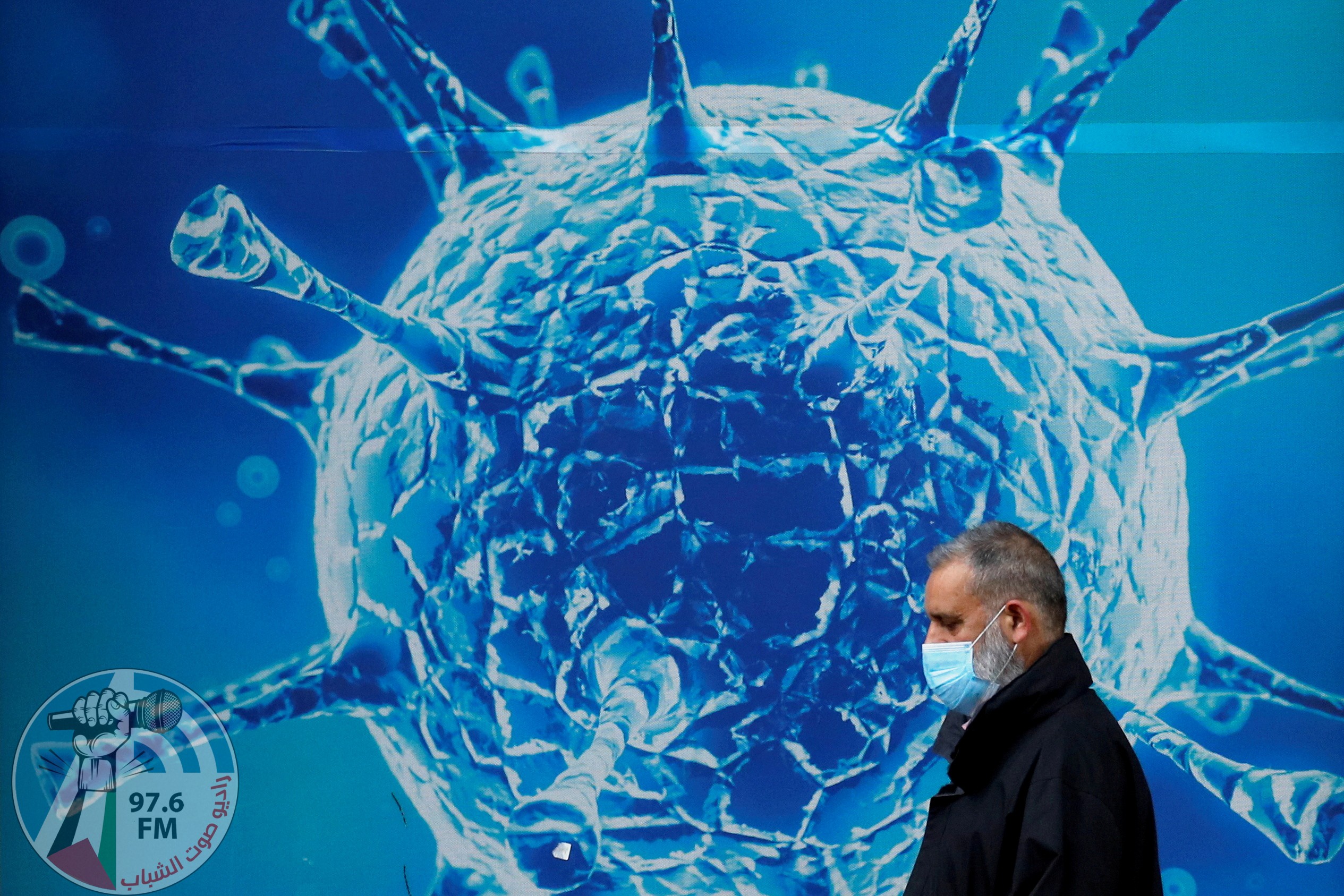FILE PHOTO: A man wearing a protective face mask walks past an illustration of a virus outside a regional science centre amid the coronavirus disease (COVID-19) outbreak, in Oldham, Britain August 3, 2020. REUTERS/Phil Noble/File Photo