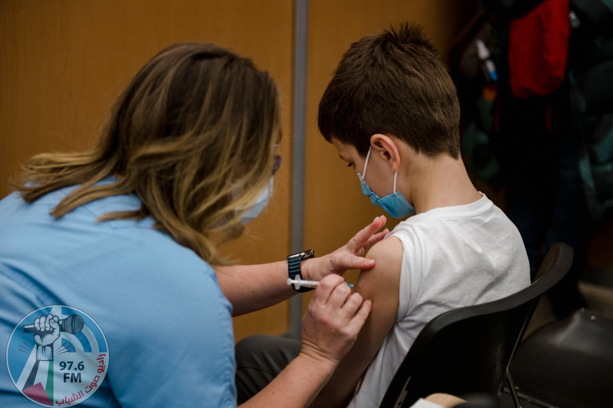 A child, 11, receives the Pfizer-BioNTech Covid-19 vaccine for children in Montreal, Quebec on November 24, 2021. Today is the first day that children are allowed to receive the version of the vaccine designed for children aged 5 to 11 years old in Canada. (Photo by Andrej Ivanov / AFP)