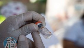 A Colombian health worker prepares a dose of the CoronaVac vaccine against COVID-19 to inoculate a Venezuelan child between 2 and 11 years old at the Francisco de Paula Santander International Bridge in the border city of Cucuta, Colombia on November 13, 2021. (Photo by Yuri CORTEZ / AFP)