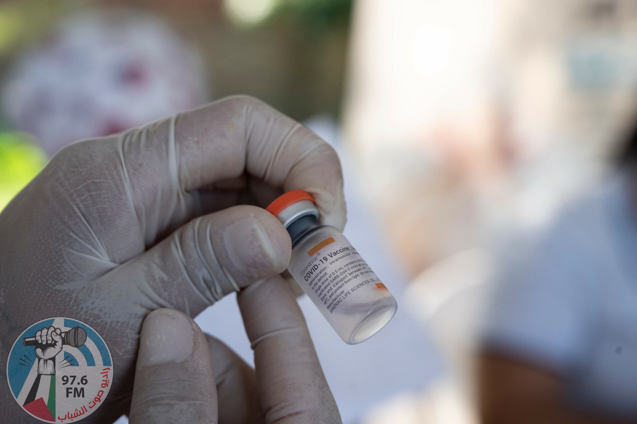 A Colombian health worker prepares a dose of the CoronaVac vaccine against COVID-19 to inoculate a Venezuelan child between 2 and 11 years old at the Francisco de Paula Santander International Bridge in the border city of Cucuta, Colombia on November 13, 2021. (Photo by Yuri CORTEZ / AFP)