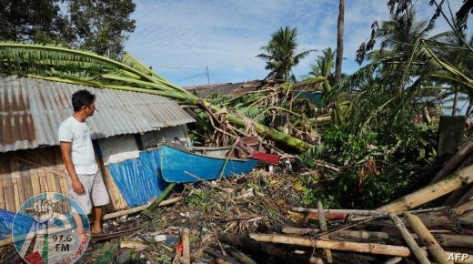 A resident looks at his damaged home in the coastal town of Dulag in Leyte province on December 17, 2021, a day after Super Typhoon Rai hit. (Photo by Bobbie ALOTA / AFP)