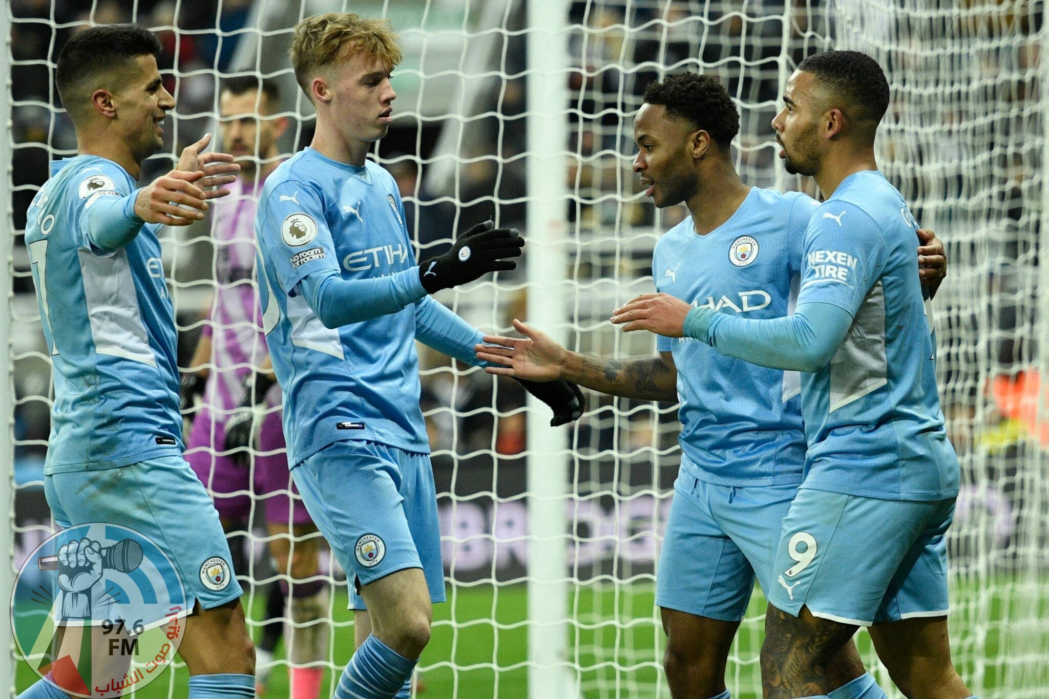 Manchester City's English midfielder Raheem Sterling (2nd R) celebrates with teammates after scoring their fourth goal during the English Premier League football match between Newcastle United and Manchester City at St James' Park in Newcastle-upon-Tyne, north east England on December 19, 2021. RESTRICTED TO EDITORIAL USE. No use with unauthorized audio, video, data, fixture lists, club/league logos or 'live' services. Online in-match use limited to 120 images. An additional 40 images may be used in extra time. No video emulation. Social media in-match use limited to 120 images. An additional 40 images may be used in extra time. No use in betting publications, games or single club/league/player publications. (Photo by Oli SCARFF / AFP) / RESTRICTED TO EDITORIAL USE. No use with unauthorized audio, video, data, fixture lists, club/league logos or 'live' services. Online in-match use limited to 120 images. An additional 40 images may be used in extra time. No video emulation. Social media in-match use limited to 120 images. An additional 40 images may be used in extra time. No use in betting publications, games or single club/league/player publications.