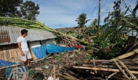 A resident looks at his damaged home in the coastal town of Dulag in Leyte province on December 17, 2021, a day after Super Typhoon Rai hit. (Photo by Bobbie ALOTA / AFP)