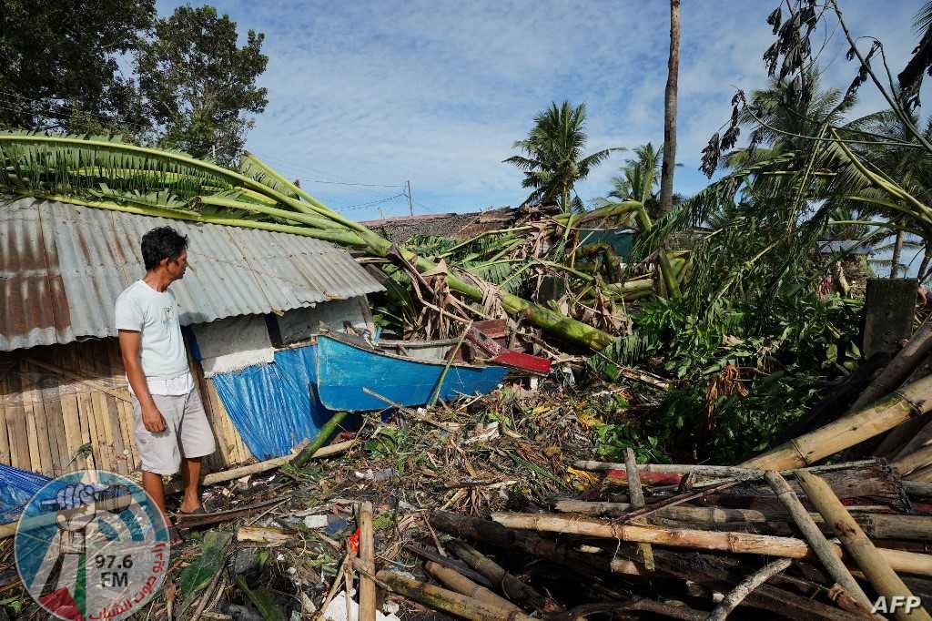 A resident looks at his damaged home in the coastal town of Dulag in Leyte province on December 17, 2021, a day after Super Typhoon Rai hit. (Photo by Bobbie ALOTA / AFP)