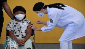 Brazilian indigenous boy Davi Xavante -the first child in Brazil to get vaccinated against COVID-19- receives the first dose of the Pfizer-BioNTech vaccine at the Clinicas hospital in Sao Paulo, Brazil, on January 14, 2022. (Photo by NELSON ALMEIDA / AFP)