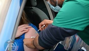 A member of the public receives a Covid-19 vaccine at a drive-through NHS (National Health Service) vaccination centre outside Ewood Park, Blackburn Rovers Football Club in Blackburn in north-west England on January 17, 2022, as the Omicron coronavirus variant spreads in the country. (Photo by Paul ELLIS / AFP)