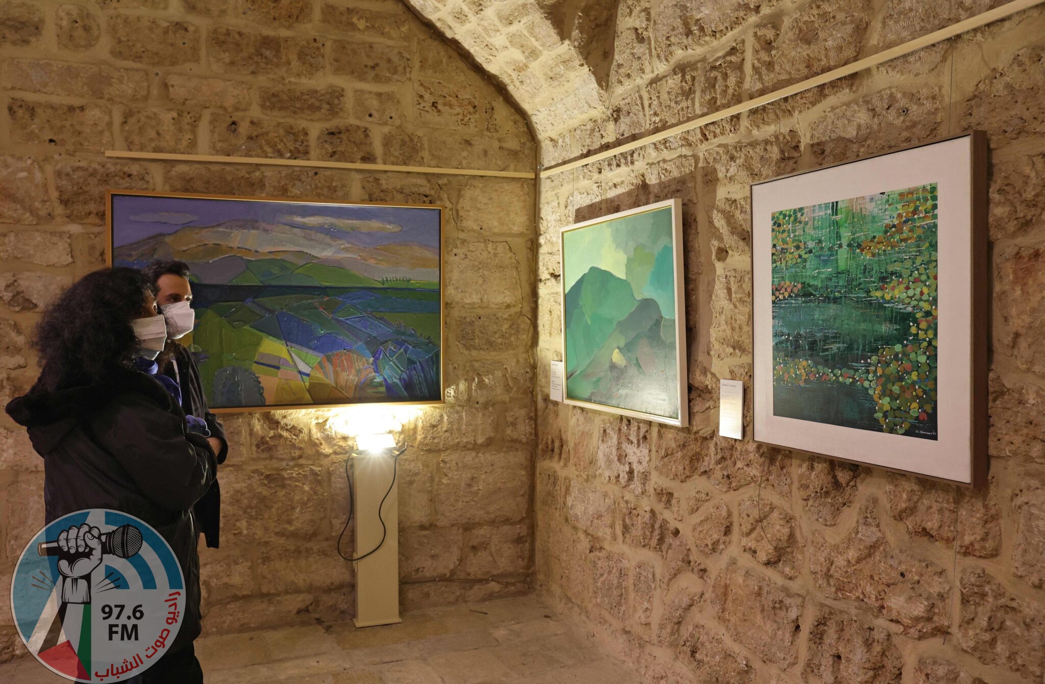 Visitors look at a paintings by Lebanese artists Shawki Chamoun (C) and Jamil Molaeb (R) during an exhibit showcasing art installations that were restored as part of a UNESCO initiative, after being damaged during the August 4 2020 port blast, at the Beirut Museum of Art in the Lebanese capital on January 20, 2022. - RESTRICTED TO EDITORIAL USE - MANDATORY MENTION OF THE ARTIST UPON PUBLICATION - TO ILLUSTRATE THE EVENT AS SPECIFIED IN THE CAPTION (Photo by ANWAR AMRO / AFP) / RESTRICTED TO EDITORIAL USE - MANDATORY MENTION OF THE ARTIST UPON PUBLICATION - TO ILLUSTRATE THE EVENT AS SPECIFIED IN THE CAPTION