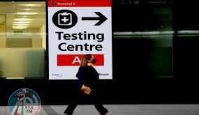 (211201) -- LONDON, Dec. 1, 2021 (Xinhua) -- A passenger walks past a placard indicating the testing center in Heathrow Airport in London, Britain, Nov. 30, 2021. British Prime Minister Boris Johnson said Saturday all travellers entering Britain must take a PCR test by the end of the second day after their arrival, and must self-isolate until they receive a negative test result. Passengers arriving in Britain from countries in Britain's travel "red list", including South Africa, from 0400 GMT on Nov. 28 will be required to book and pay for a government-approved hotel to quarantine for 10 days. Omicron, a new COVID-19 variant, has been detected in a growing number of countries and regions worldwide, prompting governments to tighten their restrictions and impose new travel bans. (Xinhua/Li Ying)