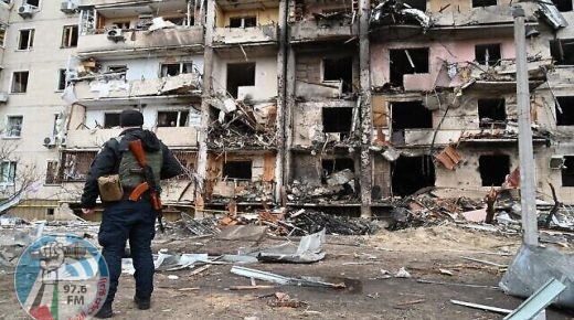 A police officer stands guard at a damaged residential building at Koshytsa Street, a suburb of the Ukrainian capital Kyiv, where a military shell allegedly hit, on February 25, 2022. - Invading Russian forces pressed deep into Ukraine as deadly battles reached the outskirts of Kyiv, with explosions heard in the capital early Friday that the besieged government described as "horrific rocket strikes". The blasts in Kyiv set off a second day of violence after Russian President Vladimir Putin defied Western warnings to unleash a full-scale ground invasion and air assault that quickly claimed dozens of lives and displaced at least 100,000 people. (Photo by GENYA SAVILOV / AFP)