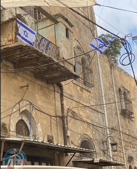 مستعمرون يرفعون علم الاحتلال على مبنى وسط مدينة الخليل