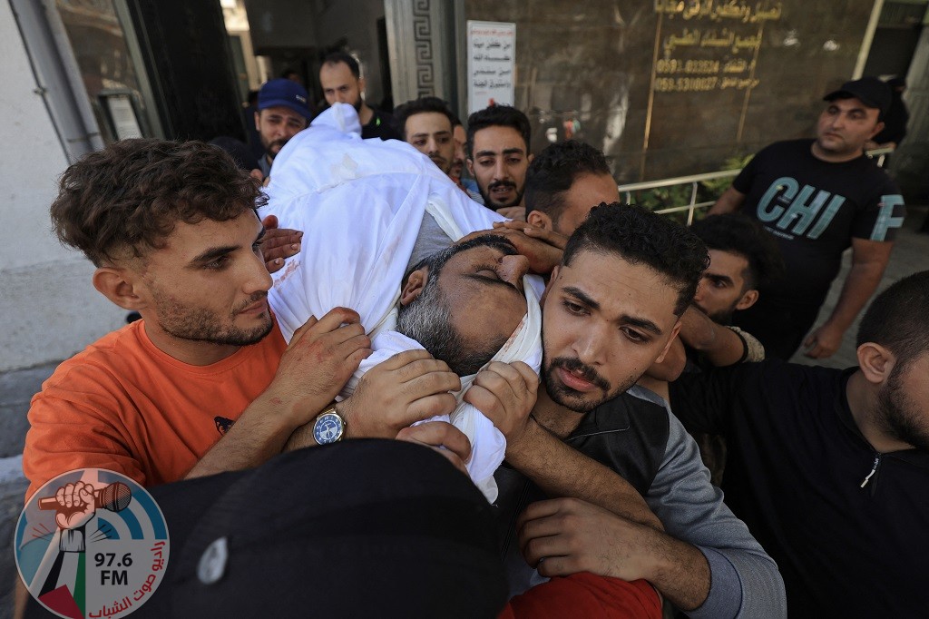 EDITORS NOTE: Graphic content / Mourners carry the body of a Palestinian killed in the latest infiltration operation into Israel, outside al-Shifa hospital in Gaza City on October 7, 2023. - Palestinian militants have begun a "war" against Israel which they infiltrated by air, sea and land from the blockaded Gaza Strip, Israeli officials said, a major escalation in the Israeli-Palestinian conflict. (Photo by Mahmud HAMS / AFP)